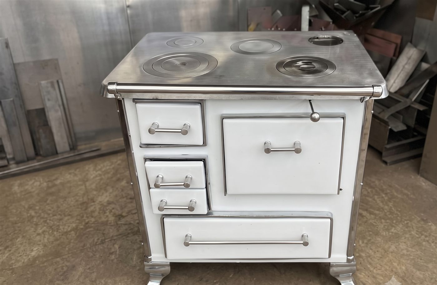 Cocina a leña esmaltada blanca con tres discos, horno y cajones, terminada en el taller