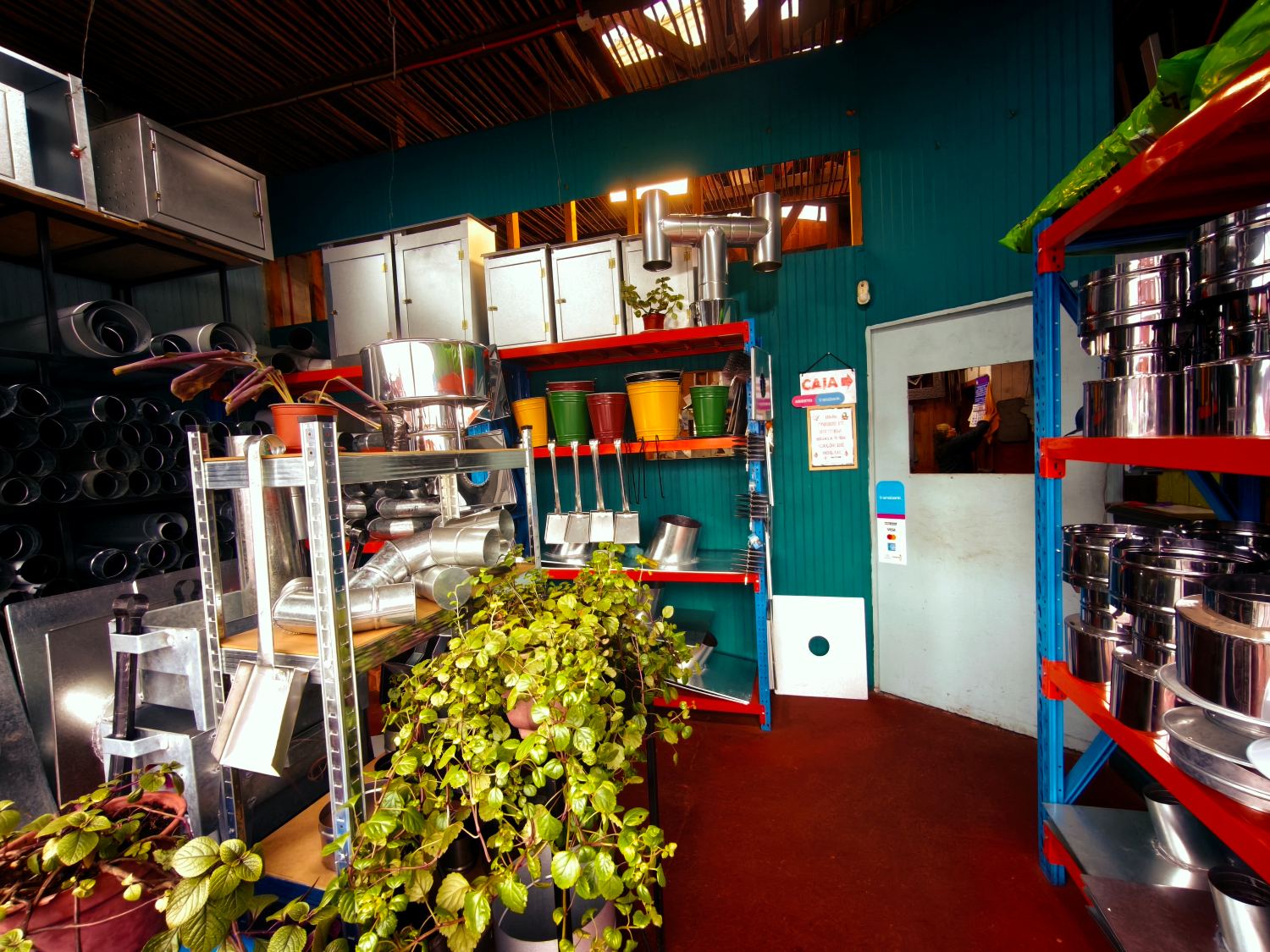 Interior del local: mostrador al fondo y estanterías con campanas, cañones y tarros